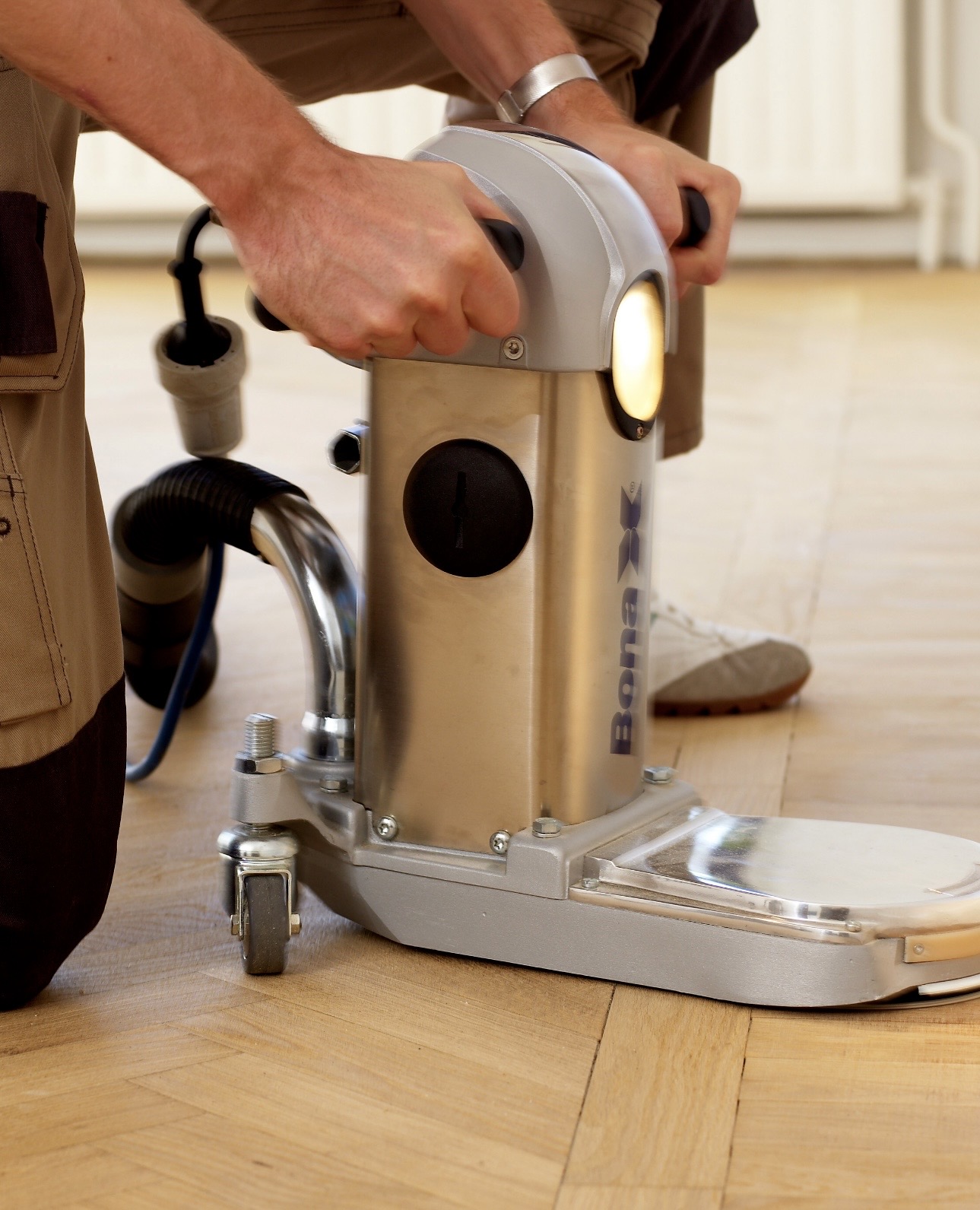 Ponceuse professionnelle sur un parquet en point de Hongrie